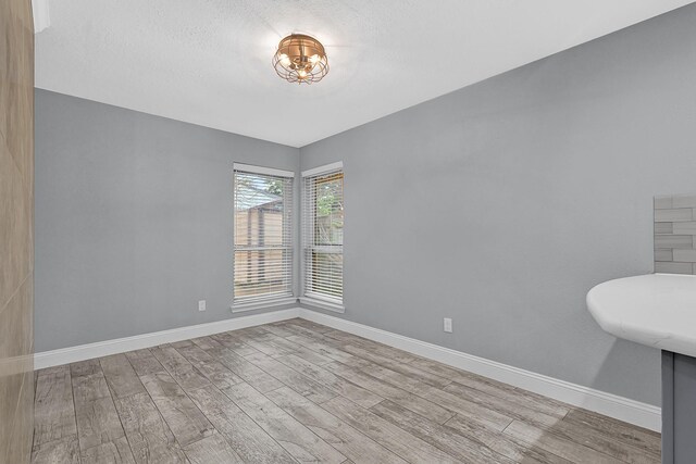 unfurnished room featuring wood finished floors and baseboards