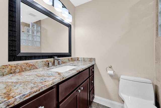 bathroom with visible vents, baseboards, vanity, and toilet
