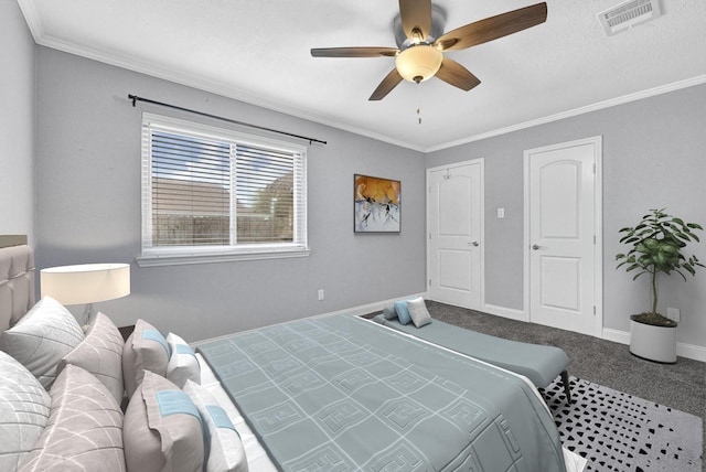 carpeted bedroom with visible vents, crown molding, baseboards, and ceiling fan