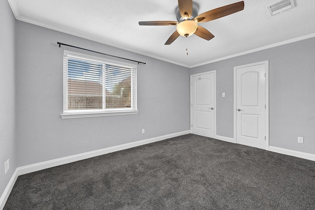 unfurnished bedroom featuring dark carpet, baseboards, crown molding, and visible vents