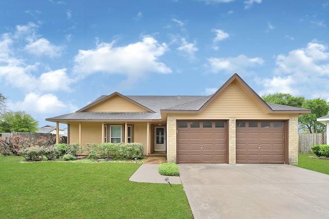ranch-style home featuring an attached garage, driveway, fence, and a front yard