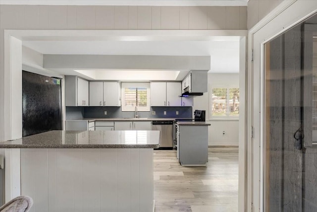 1330 Saxony Ln, Houston, TX 77058 - kitchen with a peninsula, light wood-style flooring, a wealth of natural light, and stainless steel appliances