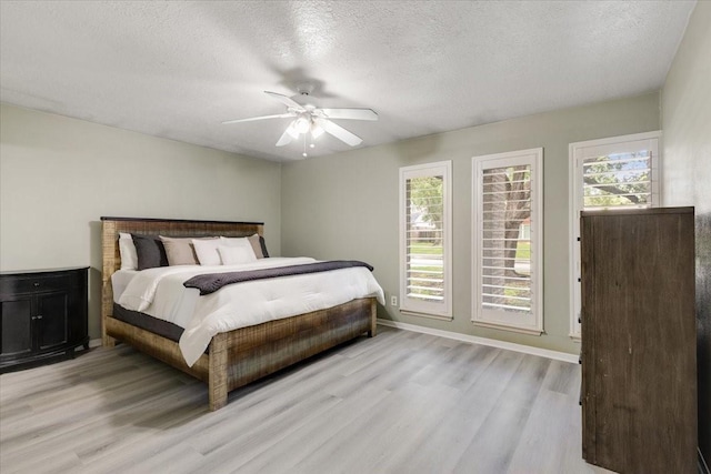 1330 Saxony Ln, Houston, TX 77058 - bedroom featuring ceiling fan, multiple windows, light wood finished floors, and a textured ceiling