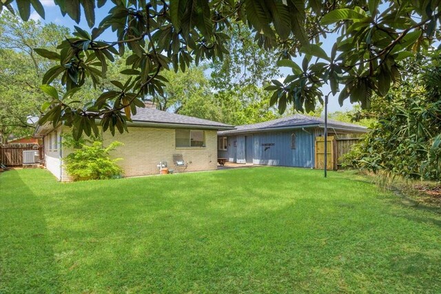 1330 Saxony Ln, Houston, TX 77058 - rear view of house featuring fence, a lawn, brick siding, and central air condition unit