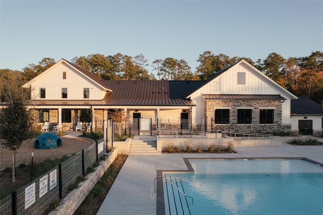 12170 Ridge Top Dr, Conroe, TX 77304 - rear view of property featuring fence, a patio, a fenced in pool, metal roof, and a standing seam roof