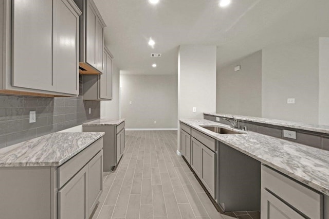 26400 Cooperstown Way, Splendora, TX 77372 - kitchen featuring a sink, light stone counters, and gray cabinets
