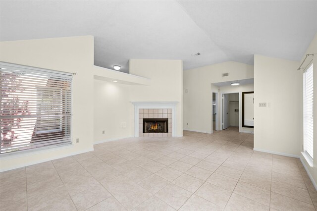 17402 Eastwood Cir, Houston, TX 77095 - unfurnished living room featuring light tile patterned floors, a tile fireplace, high vaulted ceiling, and baseboards