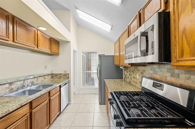17402 Eastwood Cir, Houston, TX 77095 - kitchen with appliances with stainless steel finishes, a sink, lofted ceiling, backsplash, and brown cabinets