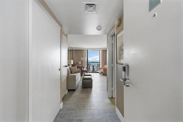 5220 Seawall Blvd Unit 738D, Galveston, TX 77551 - hallway with baseboards, stone tile floors, and visible vents