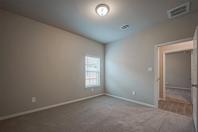 spare room with baseboards, carpet flooring, and visible vents