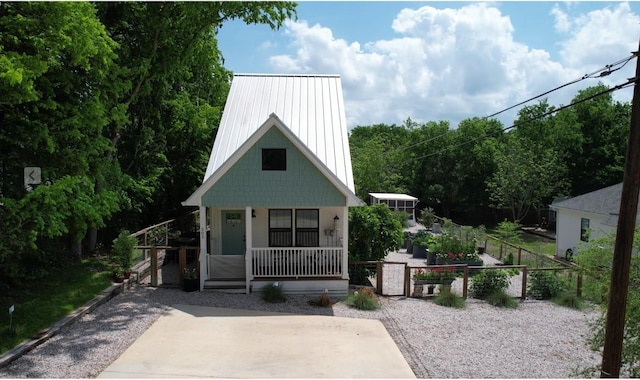 bungalow featuring a gate, metal roof, covered porch, and fence