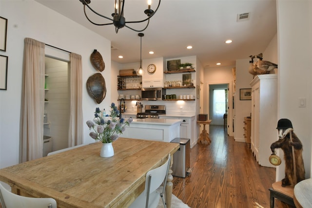 dining area featuring a notable chandelier, dark wood-type flooring, visible vents, and recessed lighting