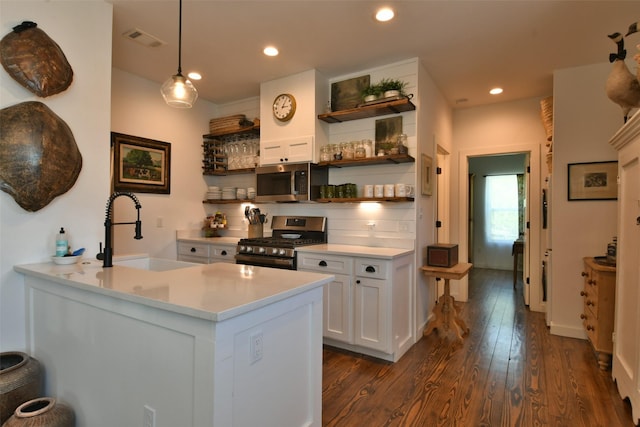 kitchen featuring open shelves, a sink, stainless steel appliances, dark wood-style flooring, and visible vents