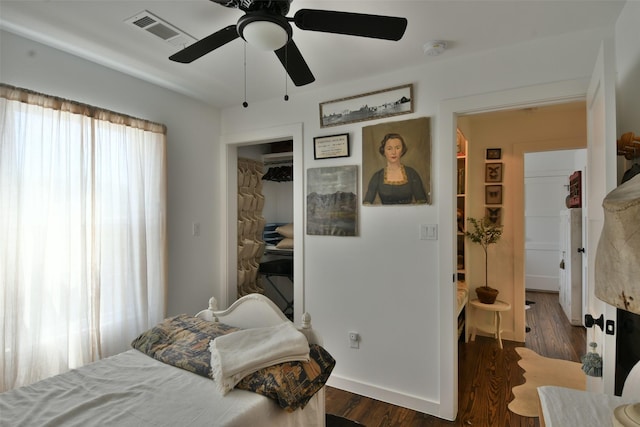 bedroom with dark wood-style floors, ceiling fan, and visible vents