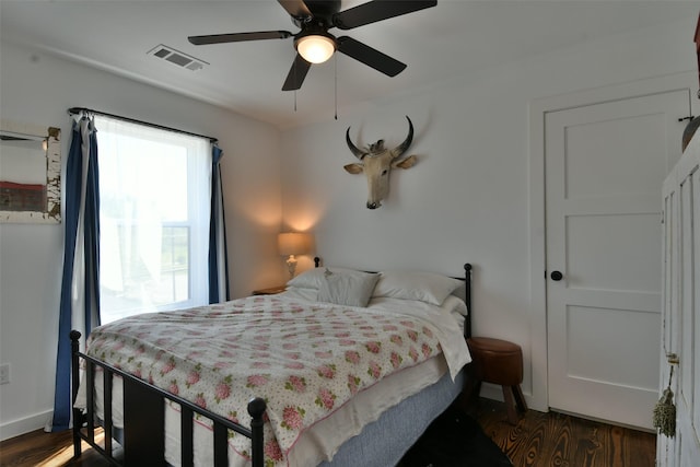 bedroom with a ceiling fan, baseboards, dark wood-style flooring, and visible vents