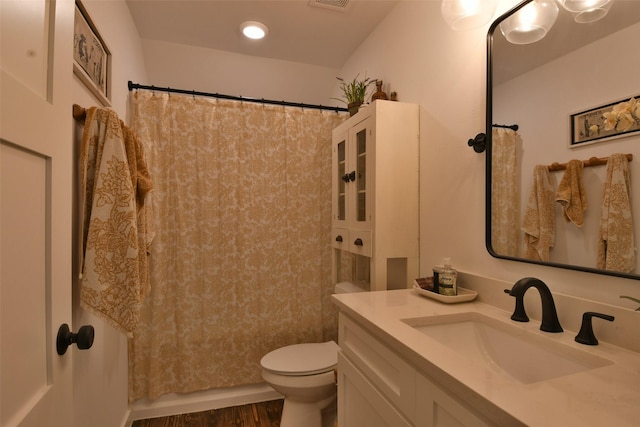 bathroom with toilet, visible vents, wood finished floors, a shower with shower curtain, and vanity