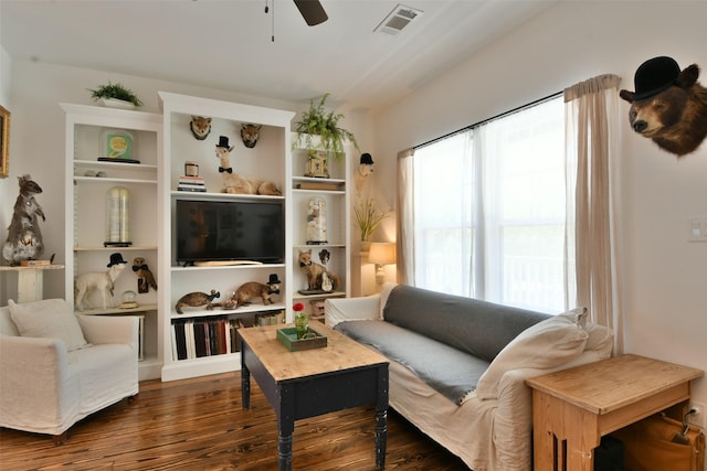 living room featuring a ceiling fan, visible vents, and dark wood-type flooring
