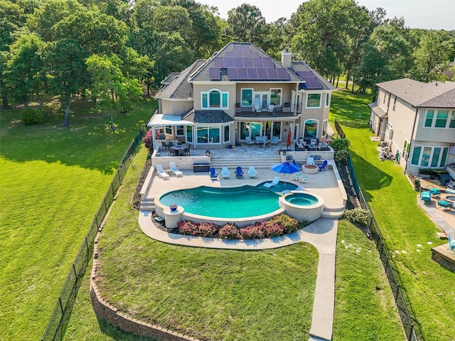 18762 Grand Harbor Pt, Montgomery, TX 77356 - rear view of property featuring outdoor dining area, roof mounted solar panels, a chimney, a pool with connected hot tub, and roof with shingles