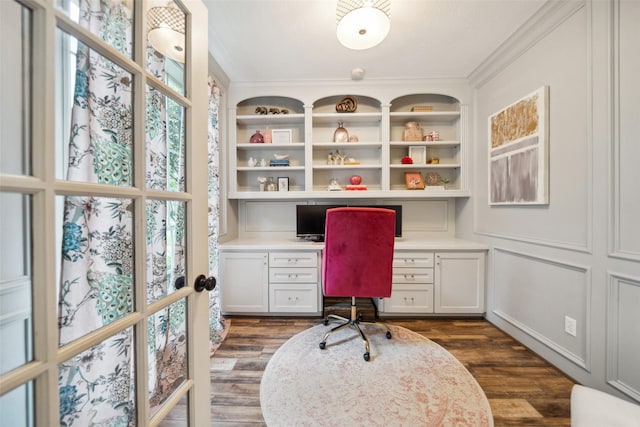 office area with built in desk, crown molding, and dark wood-style floors