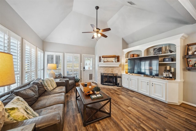 living room with vaulted ceiling, visible vents, wood finished floors, ceiling fan, and a fireplace