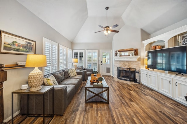 living room featuring high vaulted ceiling, wood finished floors, ceiling fan, and a stone fireplace