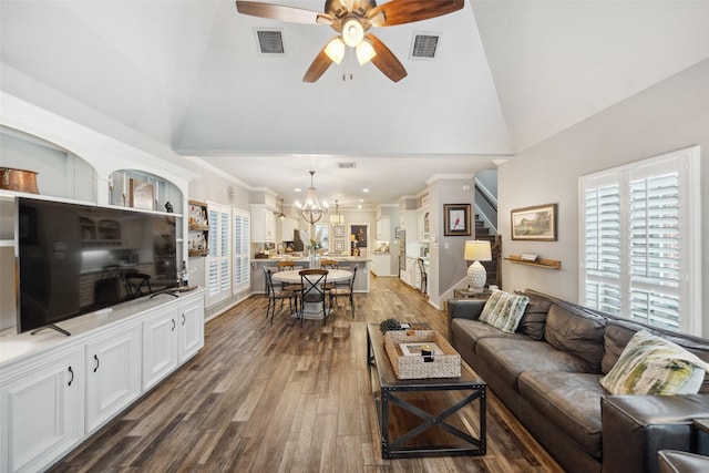 living area featuring dark wood finished floors, visible vents, high vaulted ceiling, and ceiling fan with notable chandelier