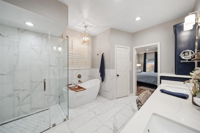 ensuite bathroom featuring a sink, a marble finish shower, marble finish floor, a soaking tub, and recessed lighting