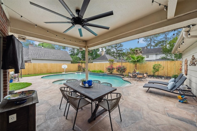 view of patio / terrace with a fenced in pool, a fenced backyard, outdoor dining area, and ceiling fan