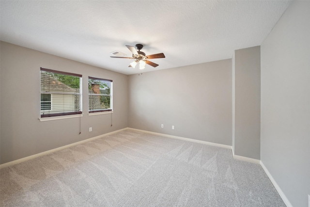 spare room with carpet floors, a ceiling fan, and baseboards