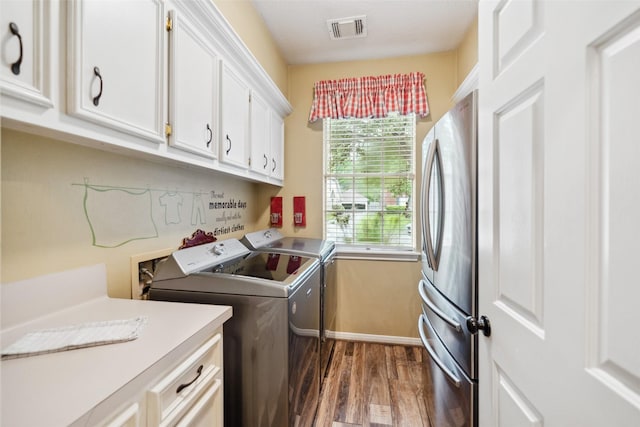clothes washing area with visible vents, independent washer and dryer, baseboards, cabinet space, and dark wood-style flooring