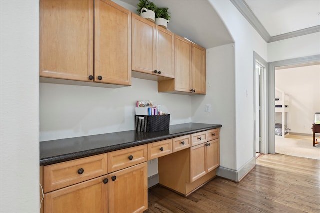 2419 Briarhurst Dr, Houston, TX 77057 - kitchen with built in study area, dark wood finished floors, crown molding, dark countertops, and light brown cabinets