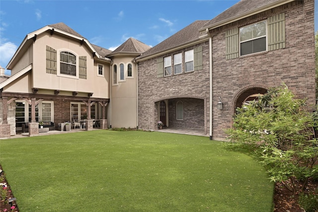 2419 Briarhurst Dr, Houston, TX 77057 - rear view of property with a patio area, an outdoor hangout area, stucco siding, and a lawn