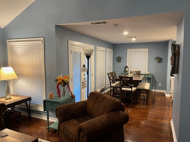 living room featuring visible vents, baseboards, and wood finished floors