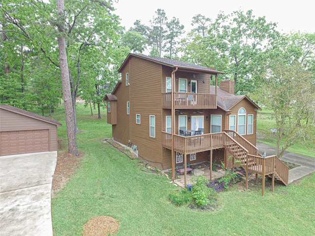 rear view of house with a ceiling fan, stairs, an outbuilding, a lawn, and roof with shingles