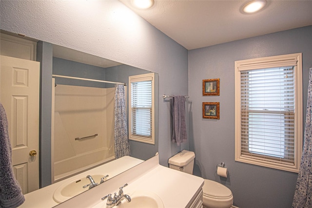 full bath featuring toilet, vanity, curtained shower, and baseboards