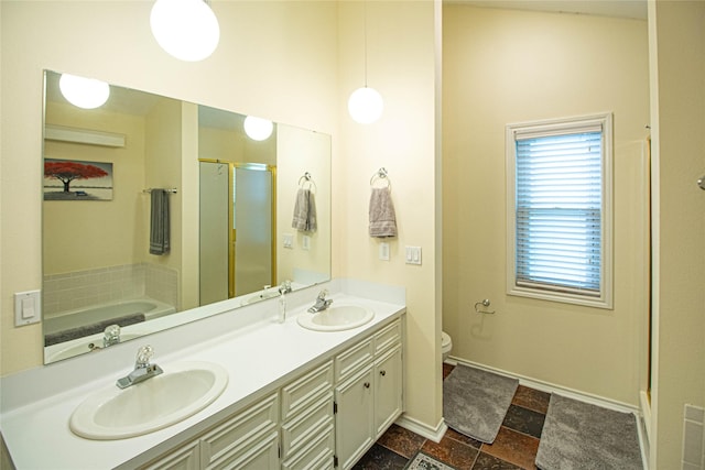 full bath featuring double vanity, toilet, a stall shower, and a sink
