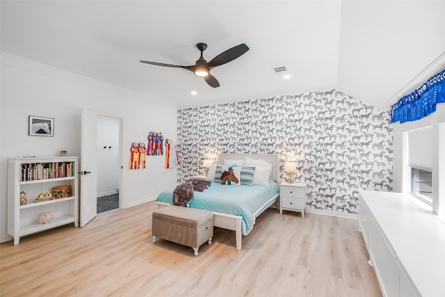 bedroom with visible vents, ornamental molding, wood finished floors, an accent wall, and wallpapered walls