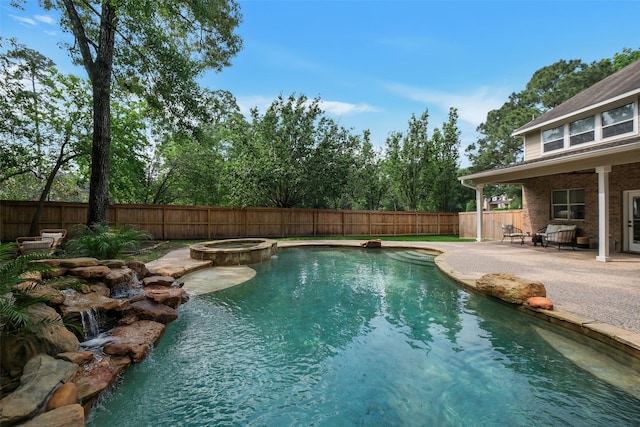 view of swimming pool with a pool with connected hot tub, a fenced backyard, and a patio area