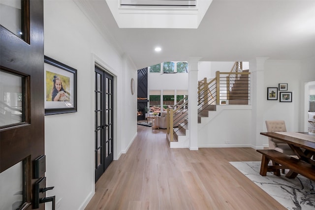 foyer entrance featuring light wood-style floors, recessed lighting, ornamental molding, and stairs