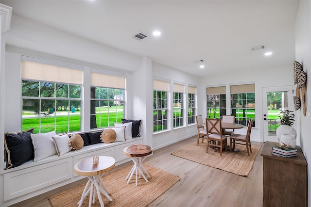 sunroom featuring an outdoor hangout area, wood finished floors, and visible vents