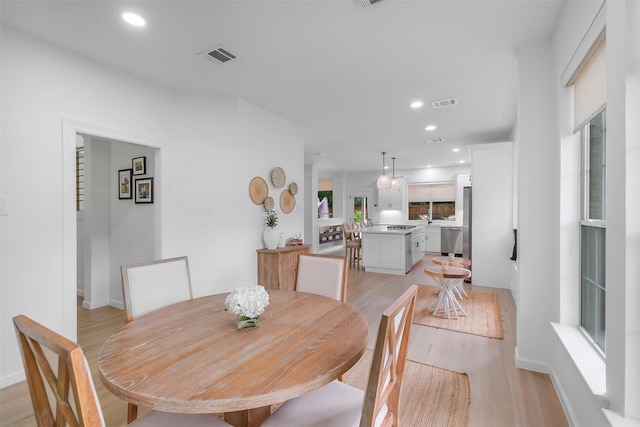 dining space with recessed lighting, baseboards, light wood finished floors, and visible vents