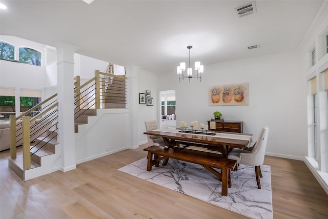 dining area featuring visible vents, light wood-style flooring, stairs, and a chandelier