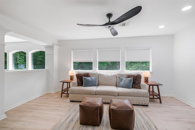 living room featuring decorative columns, baseboards, ceiling fan, recessed lighting, and light wood-style flooring