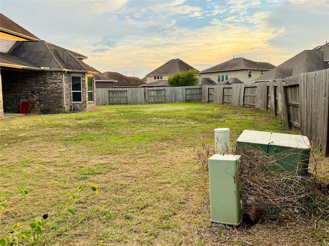 yard at dusk with a fenced backyard