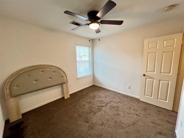 6022 Yorkglen Manor Ln, Houston, TX 77084 - unfurnished bedroom with dark colored carpet, baseboards, and a ceiling fan