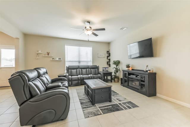living room featuring ceiling fan, baseboards, visible vents, and light tile patterned floors