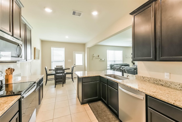 kitchen with visible vents, a sink, appliances with stainless steel finishes, and light stone counters