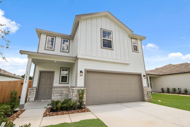 17832 Lionheart Rd, Conroe, TX 77306 - view of front facade with board and batten siding, stone siding, a garage, and driveway