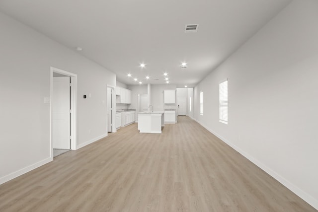 17832 Lionheart Rd, Conroe, TX 77306 - unfurnished living room with light wood-type flooring, baseboards, a sink, and recessed lighting