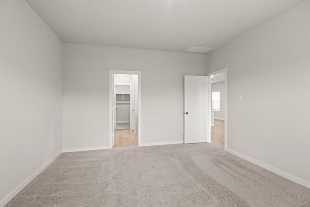 17832 Lionheart Rd, Conroe, TX 77306 - unfurnished bedroom with light carpet, baseboards, and a walk in closet